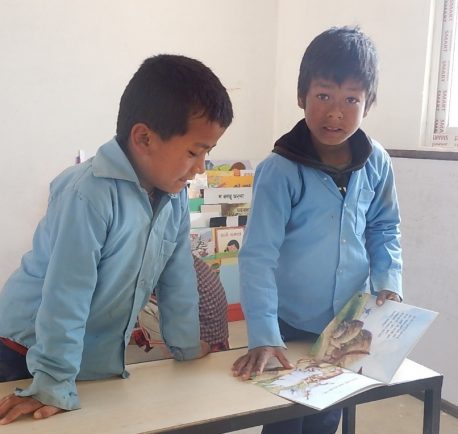 新しい校舎で絵本を開く生徒たち