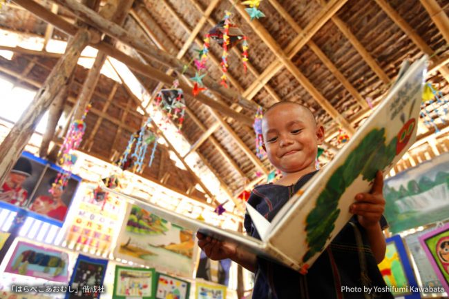 ミャンマー（ビルマ）難民キャンプの図書館で絵本「はらぺこあおむし」を手にした子ども