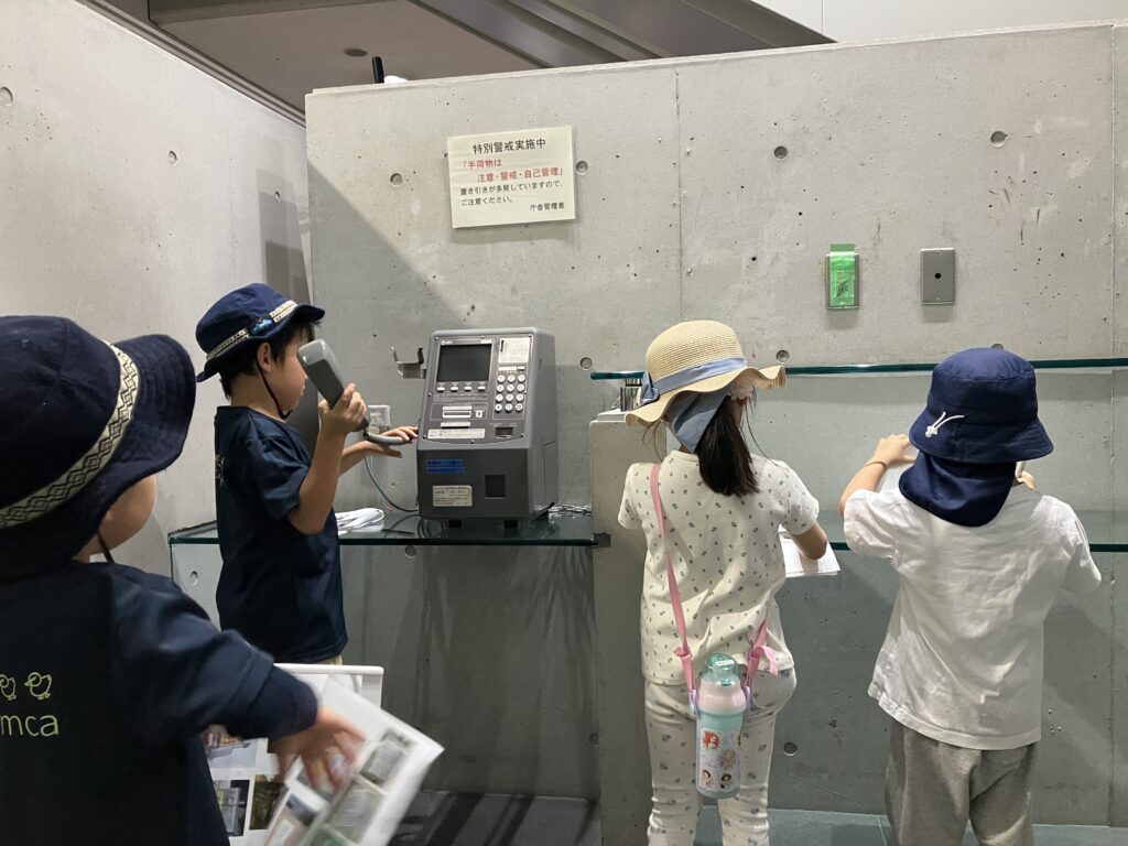 公衆電話の使い方を学ぶ子どもたち